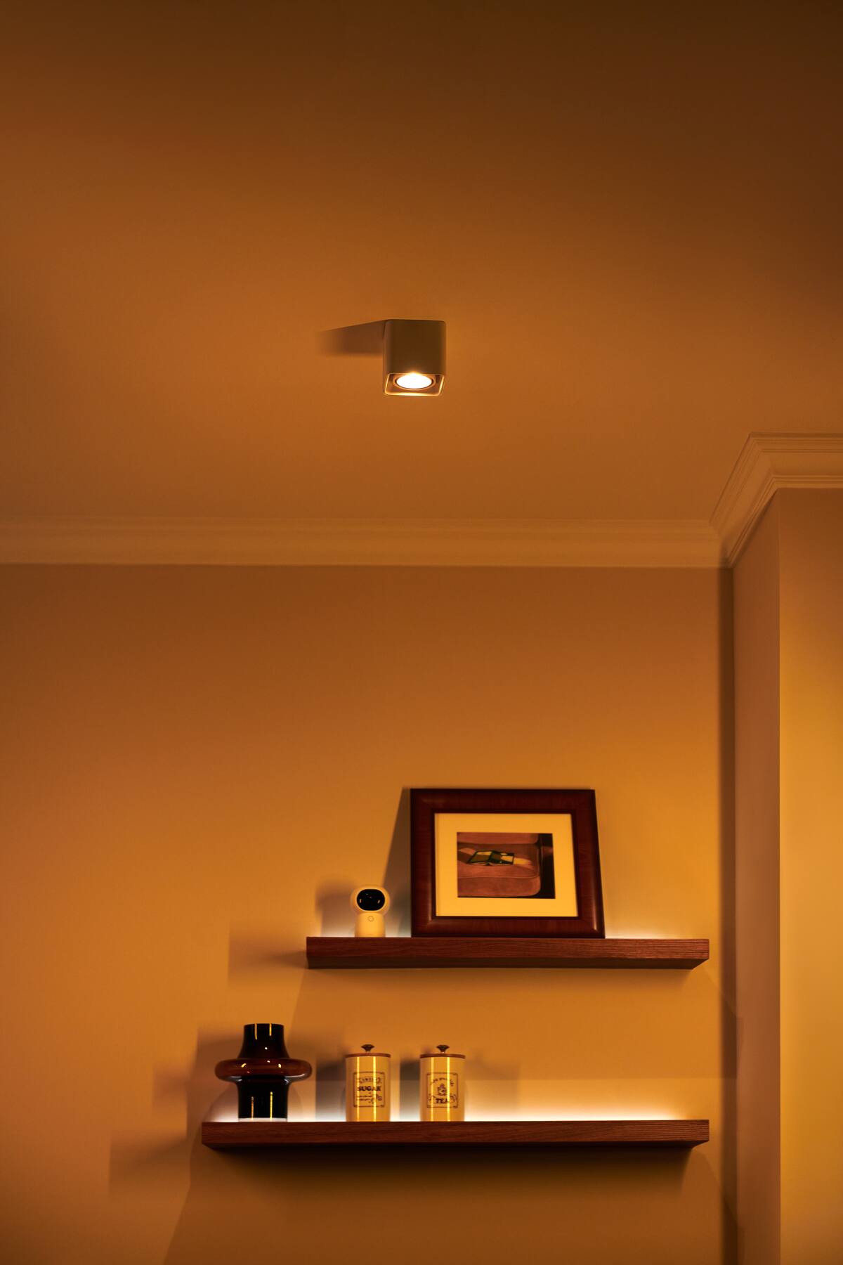 Warm Aqara evening lighting across shelves and a wall