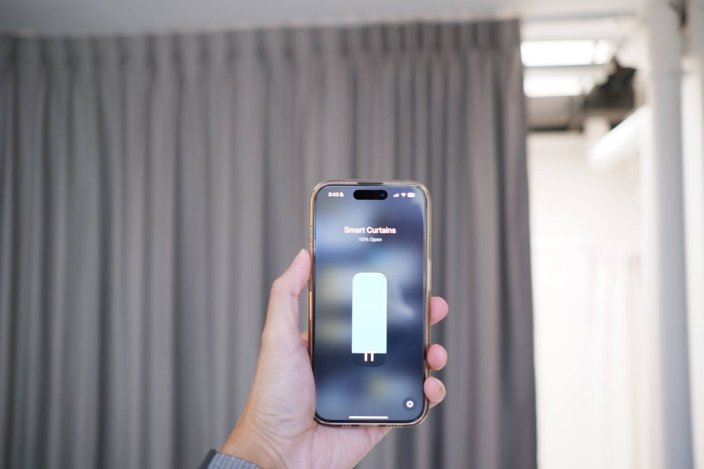 Smart curtain control shown on an iPhone in front of installed curtains