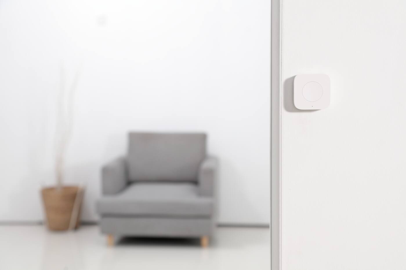 Aqara Wireless Mini Switch mounted on a wall beside a doorway