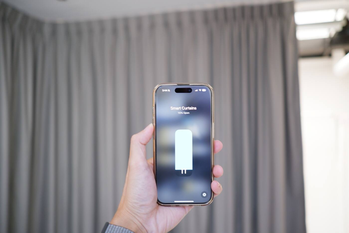 Smart curtain position displayed on an iPhone in front of the curtains