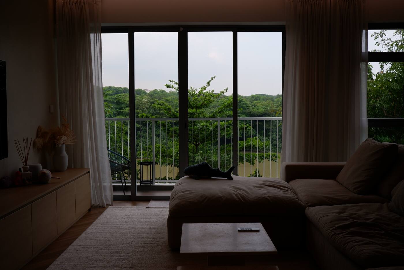 Completed living room with full-height curtains beside a wide balcony opening