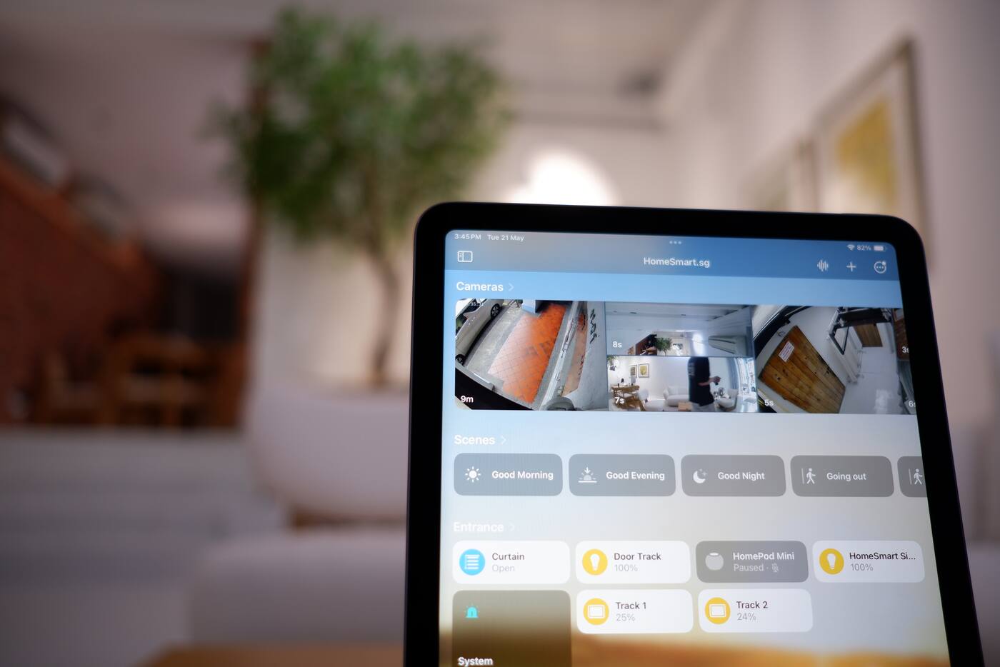 Smart home dashboard on a tablet showing rooms, cameras and controls