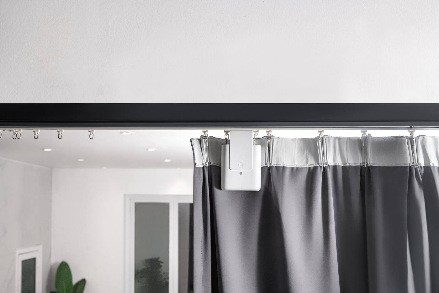Aqara Curtain Driver E1 mounted on an existing curtain track, moving grey curtains