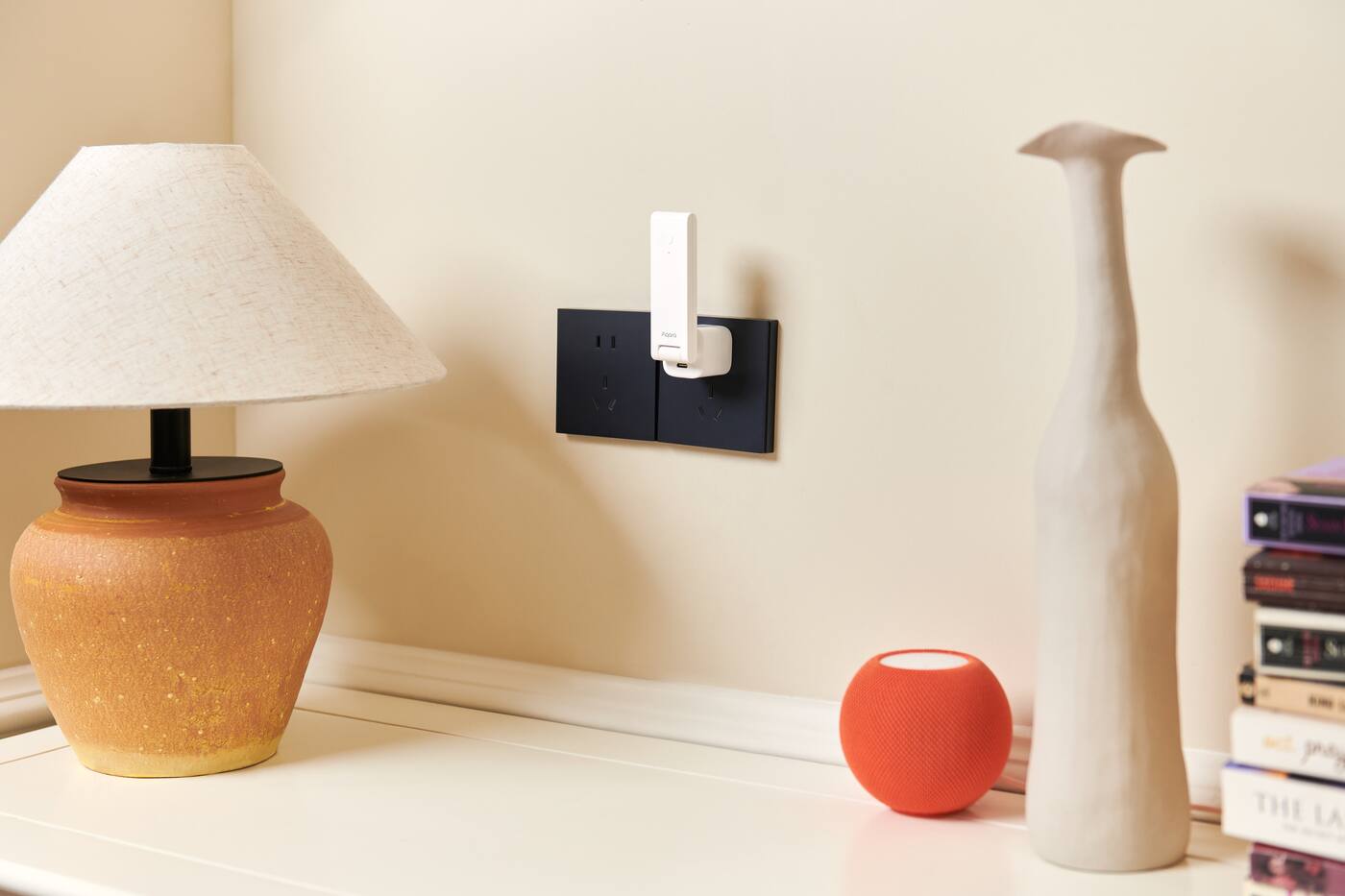 Compact Aqara hub plugged into an exposed wall socket instead of being enclosed in a cabinet