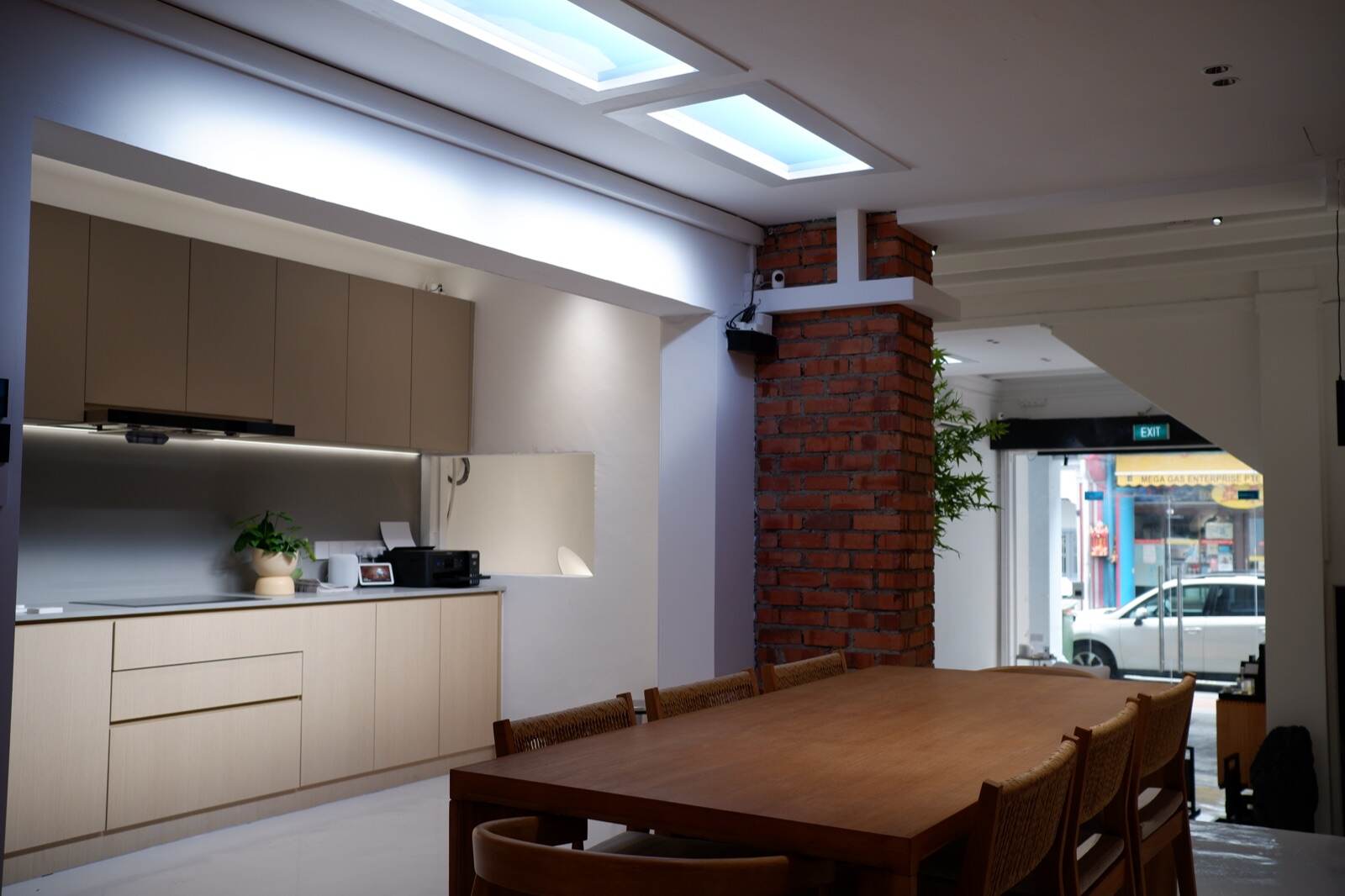 Smart lighting at the Aqara showroom in Singapore — artificial skylights, cove strips and downlights over the kitchen and dining area