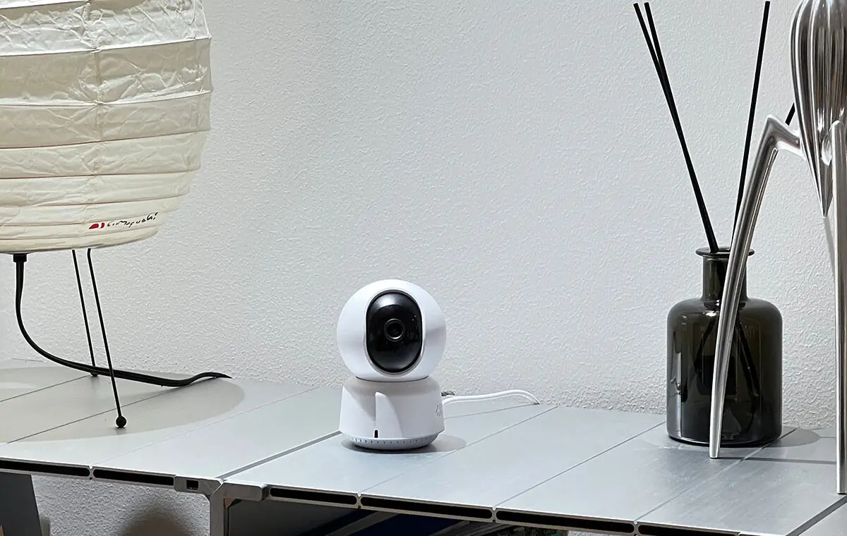Camera E1 on a side table in a bright, minimalist room