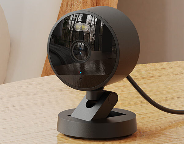 Aqara Camera G100 in black, resting on a wooden table