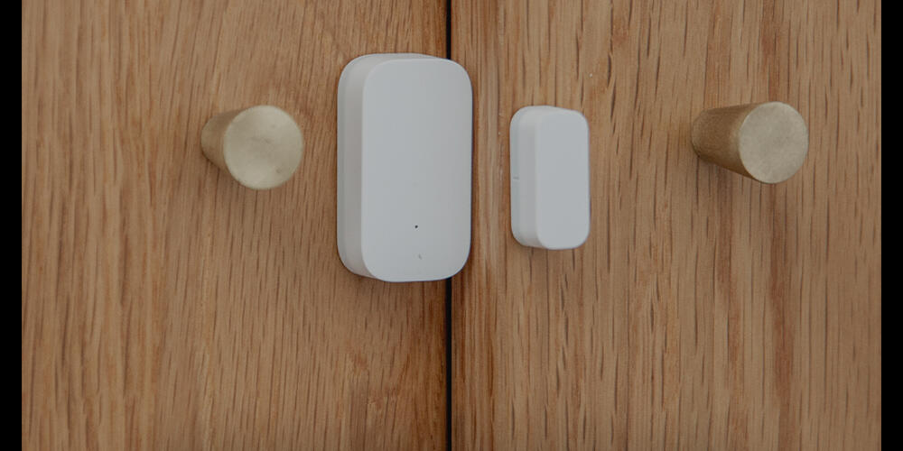 Door and Window Sensor T1 fitted to a wooden cabinet door beside its magnet