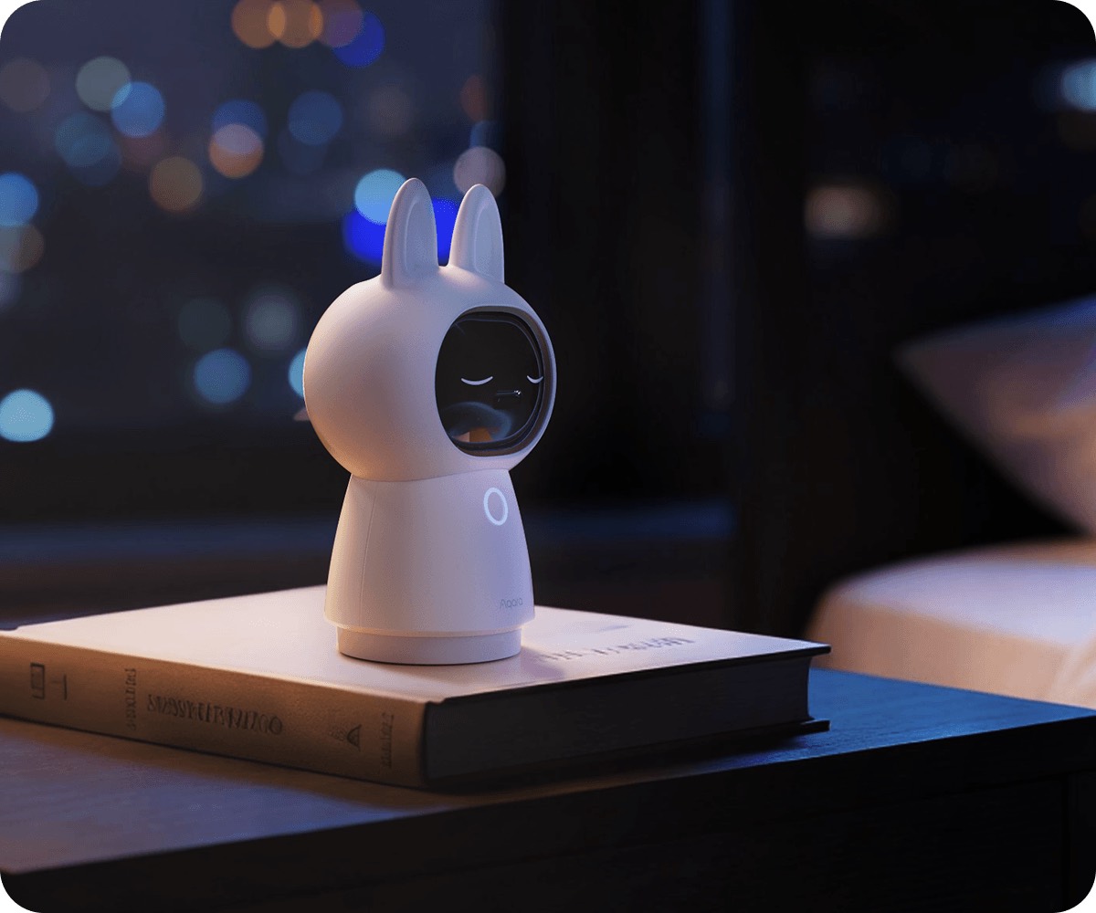 Camera Hub G350 in privacy mode with its lens shuttered, on a bedside table at night