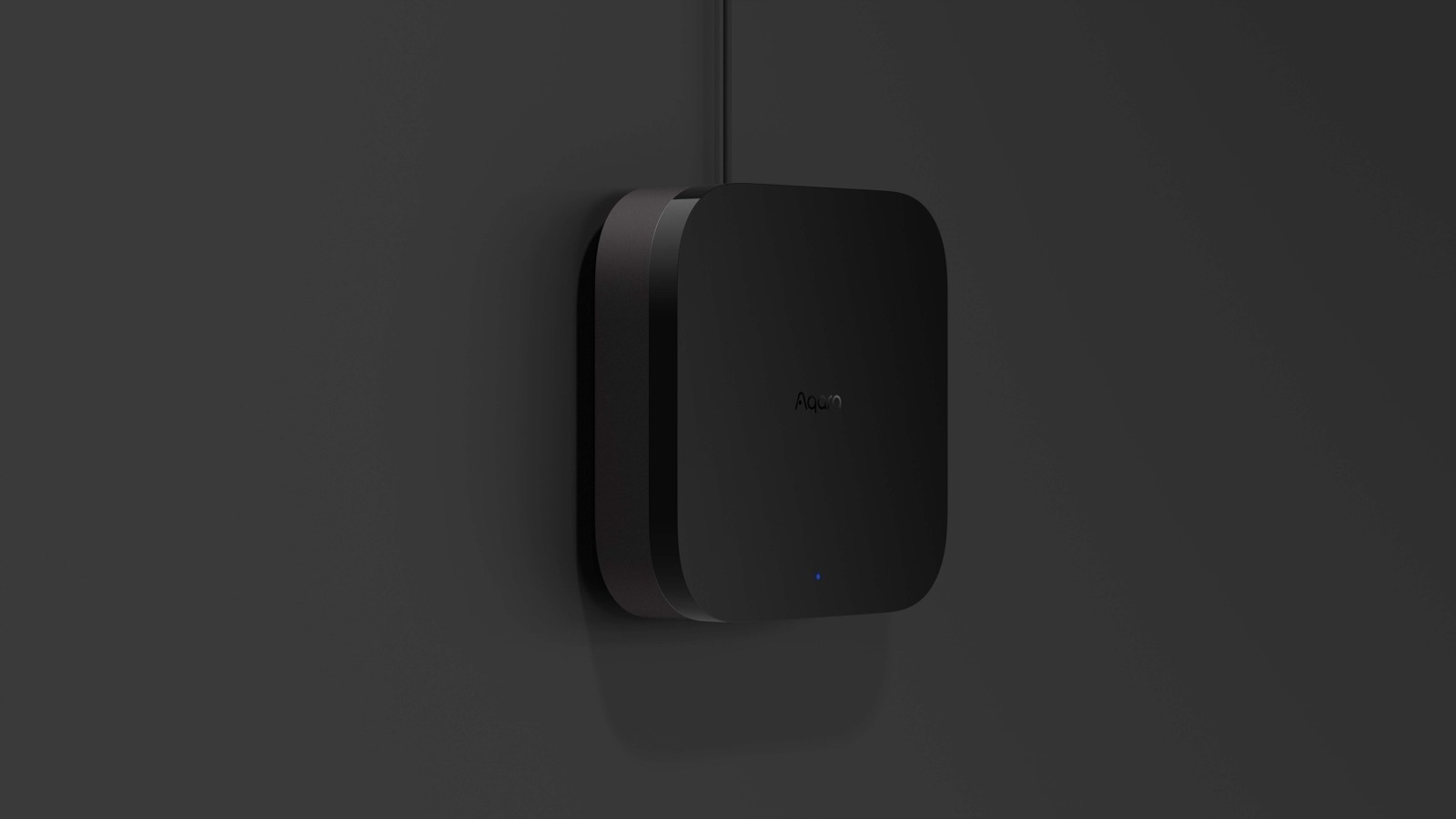Aqara Hub M3 wall-mounted against a dark backdrop, status light glowing