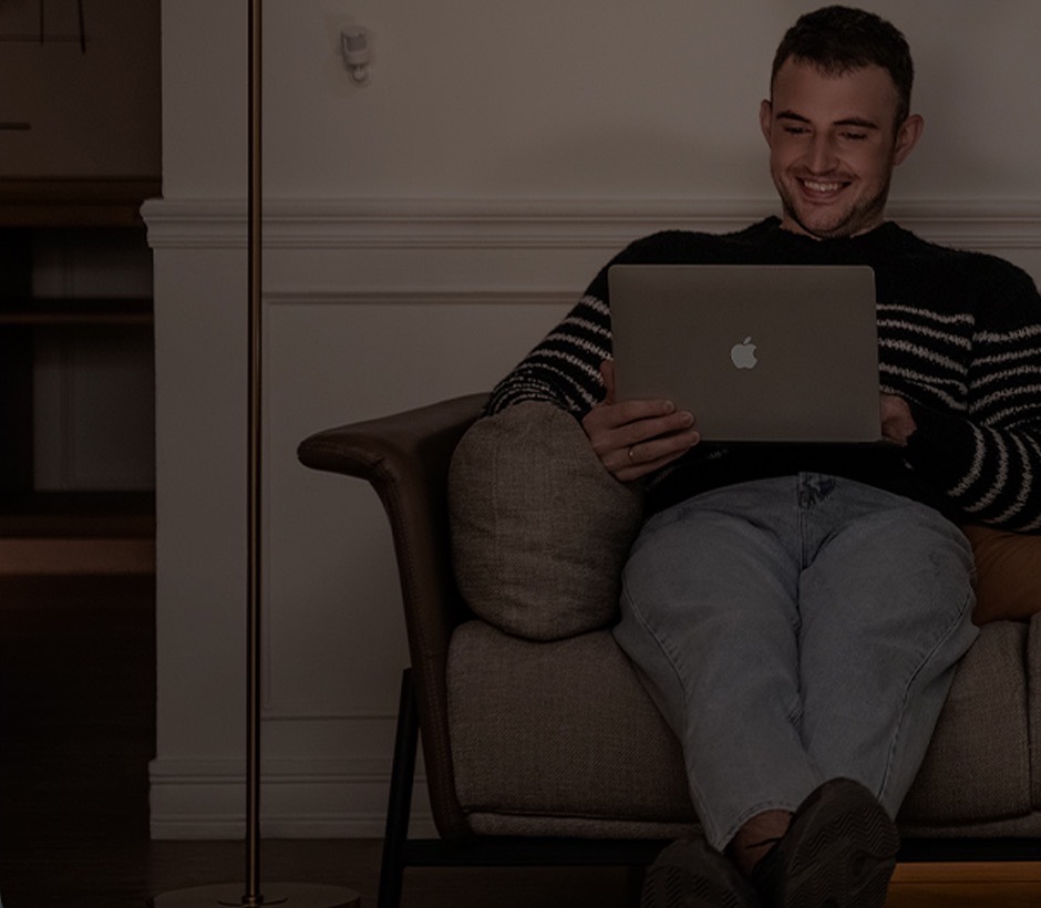 Motion Sensor P1 on the wall of a dimly lit living room where someone relaxes on the sofa