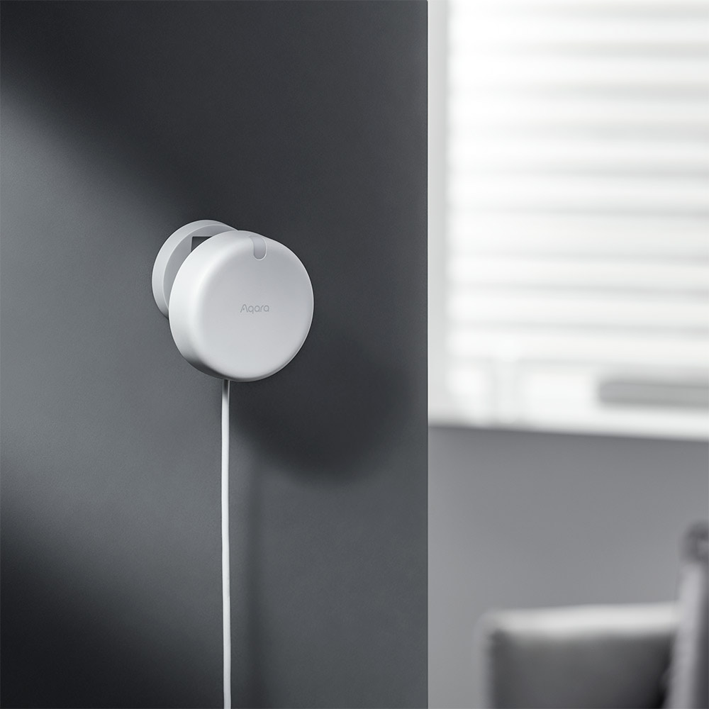 Close-up of the Presence Sensor FP2 on a dark wall beside a bright window
