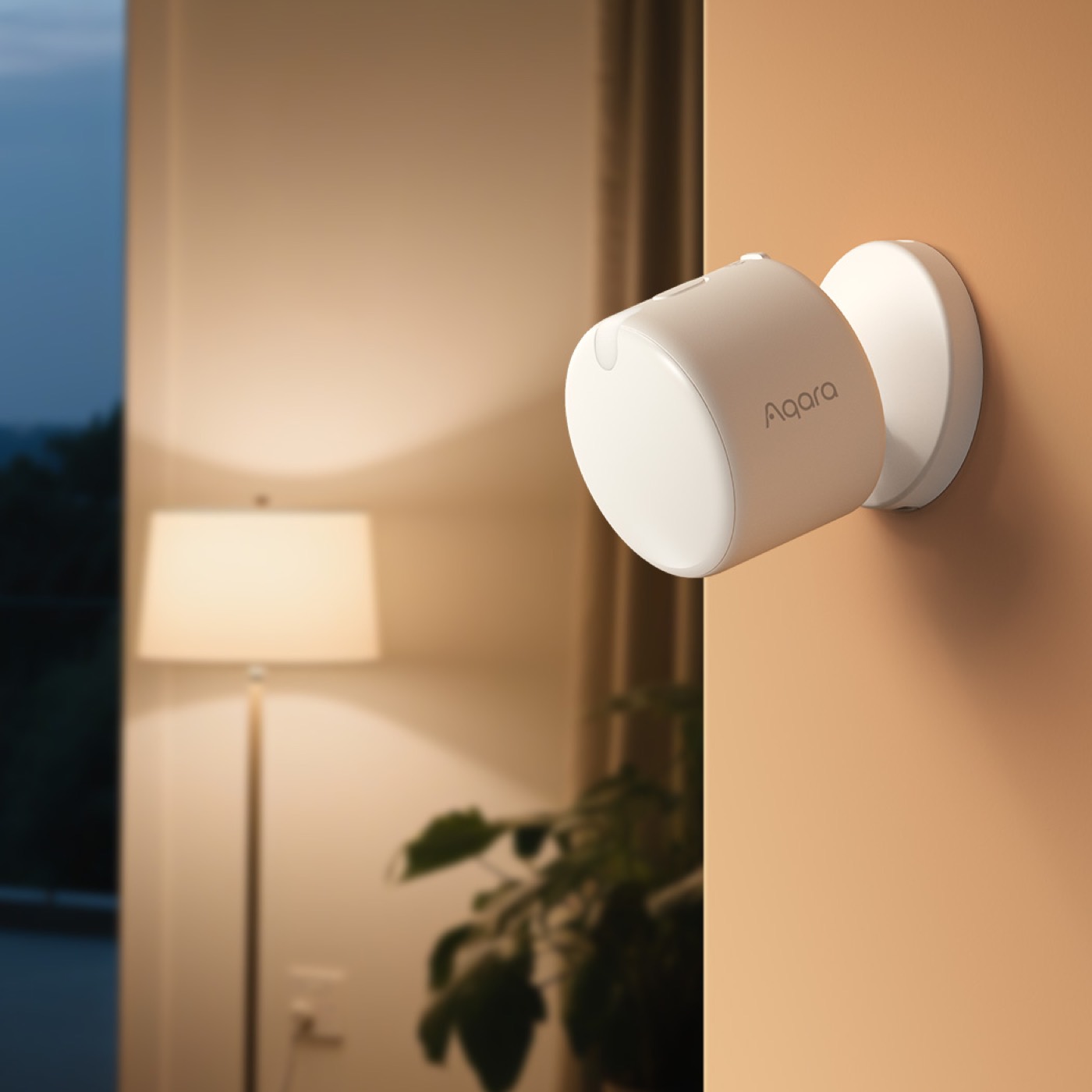 Aqara Presence Sensor FP300 mounted on a warm-lit wall beside a floor lamp at dusk