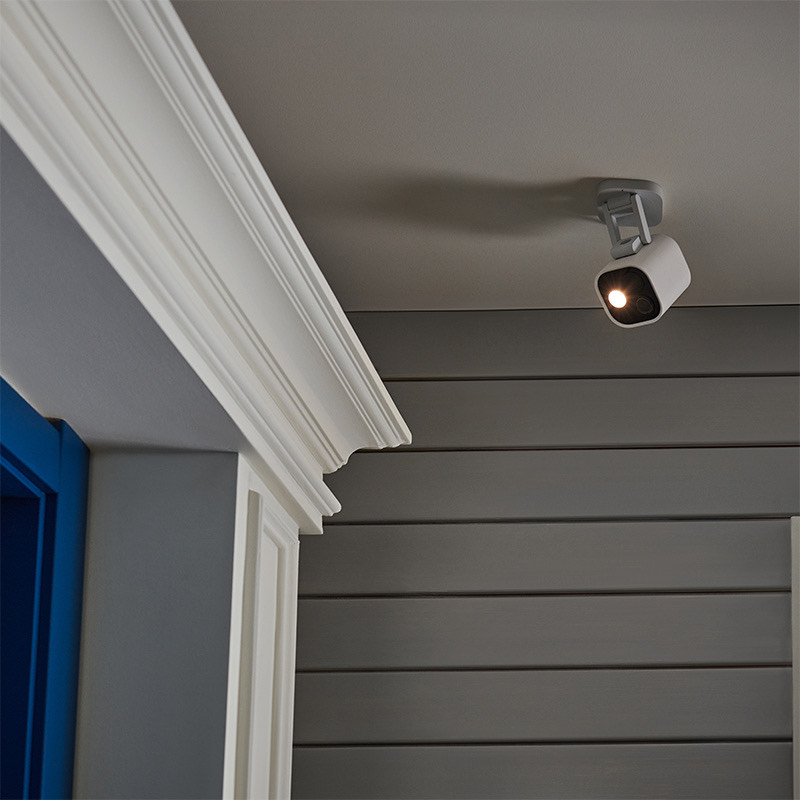 G5 Pro mounted on a porch ceiling with its spotlight glowing over a doorway at night