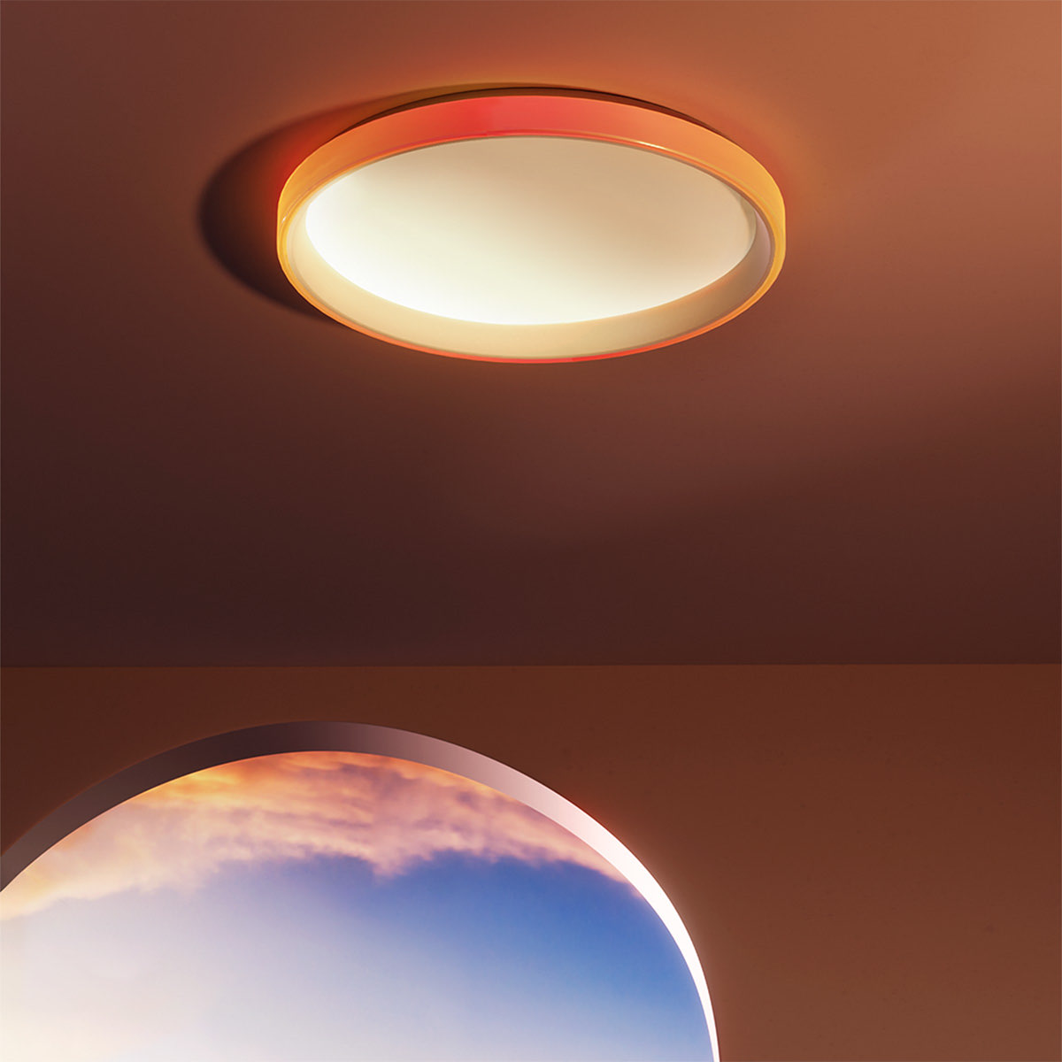 Ceiling Light T1M glowing warm white on a ceiling beside a large window at dusk