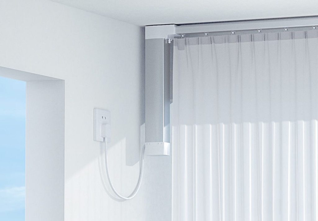 Aqara Smart Curtain Controller mounted on a ceiling track, drawing sheer curtains across a bright window