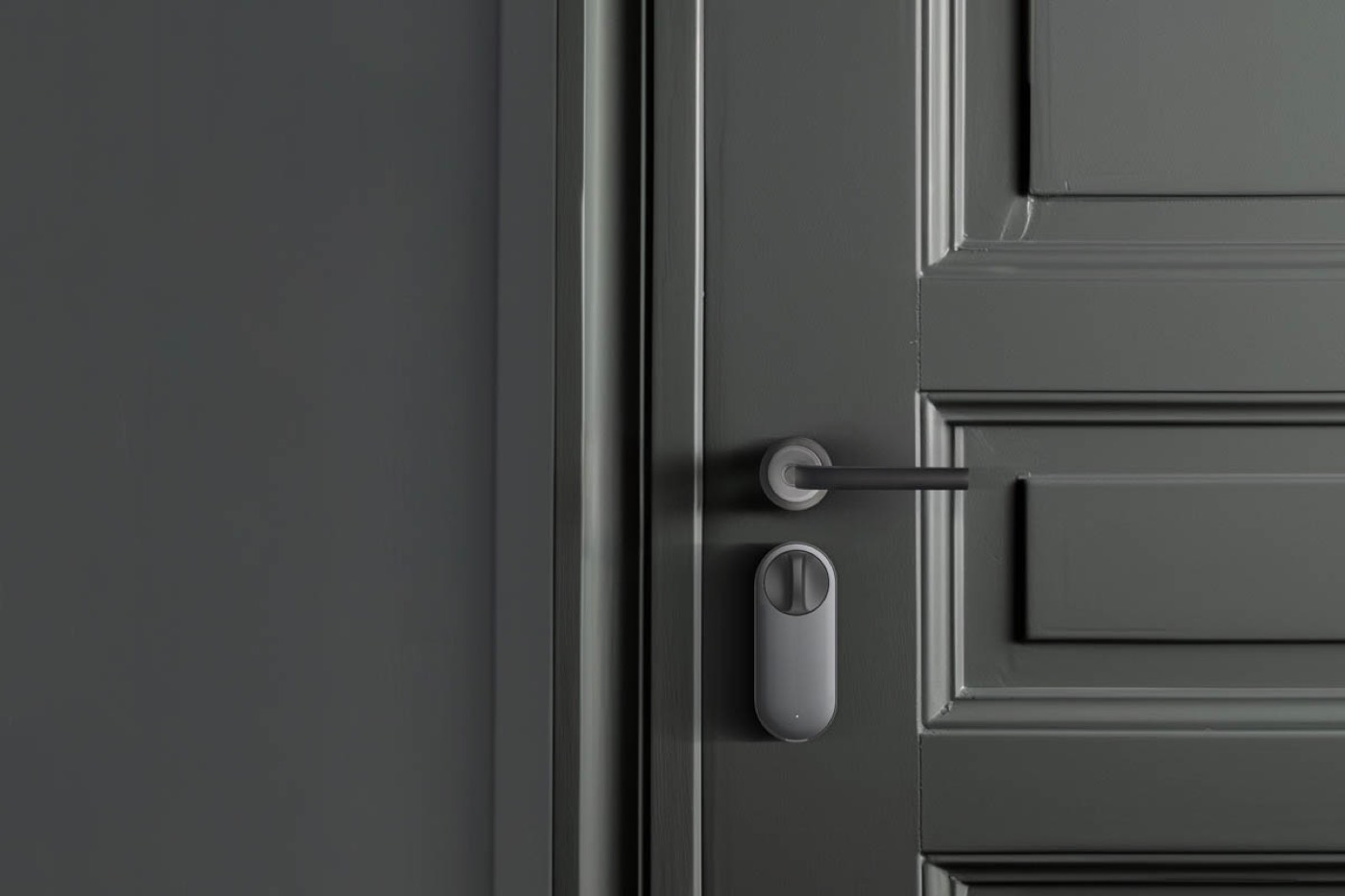 The Aqara U200 lock body installed over the interior thumbturn of a dark grey panelled door