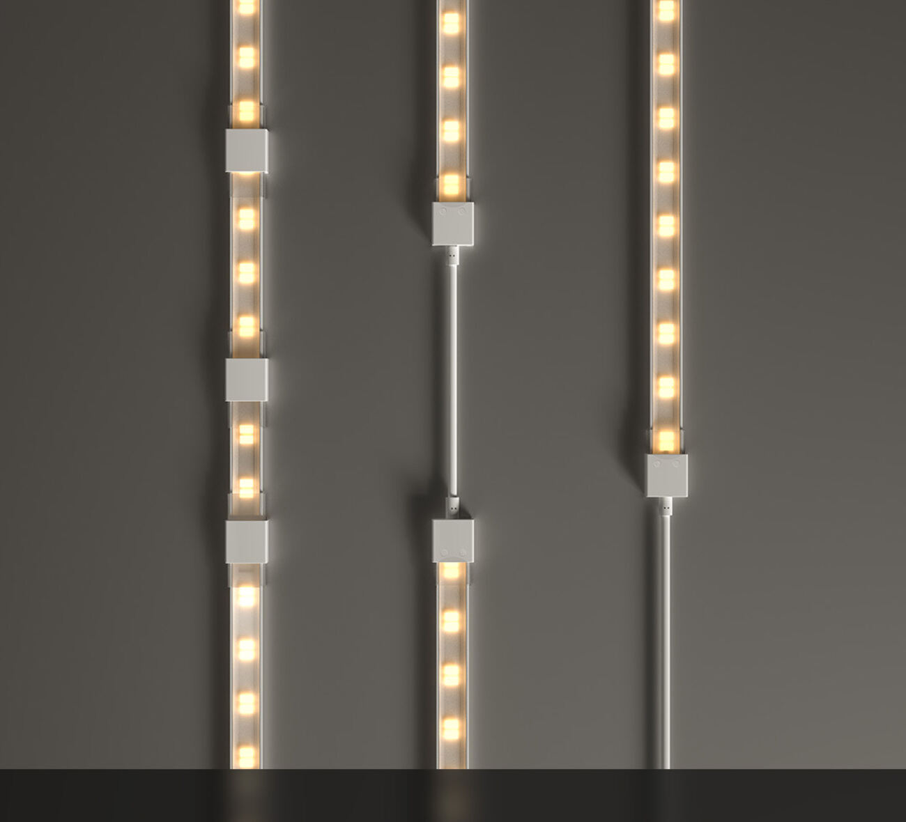 Three LED strip runs joined by solder-free connector blocks against a grey wall
