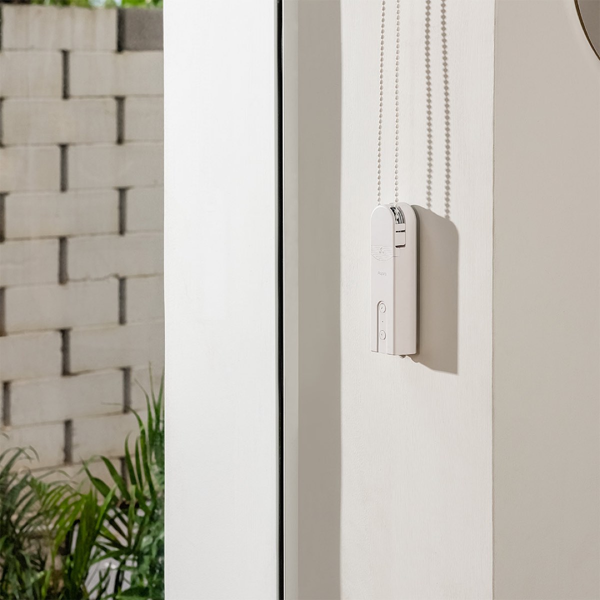 Roller Shade Driver E1 fitted to a window frame, driving the shade's beaded chain