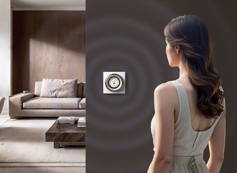 A person approaching the wall-mounted dial, waking its screen via the presence sensor