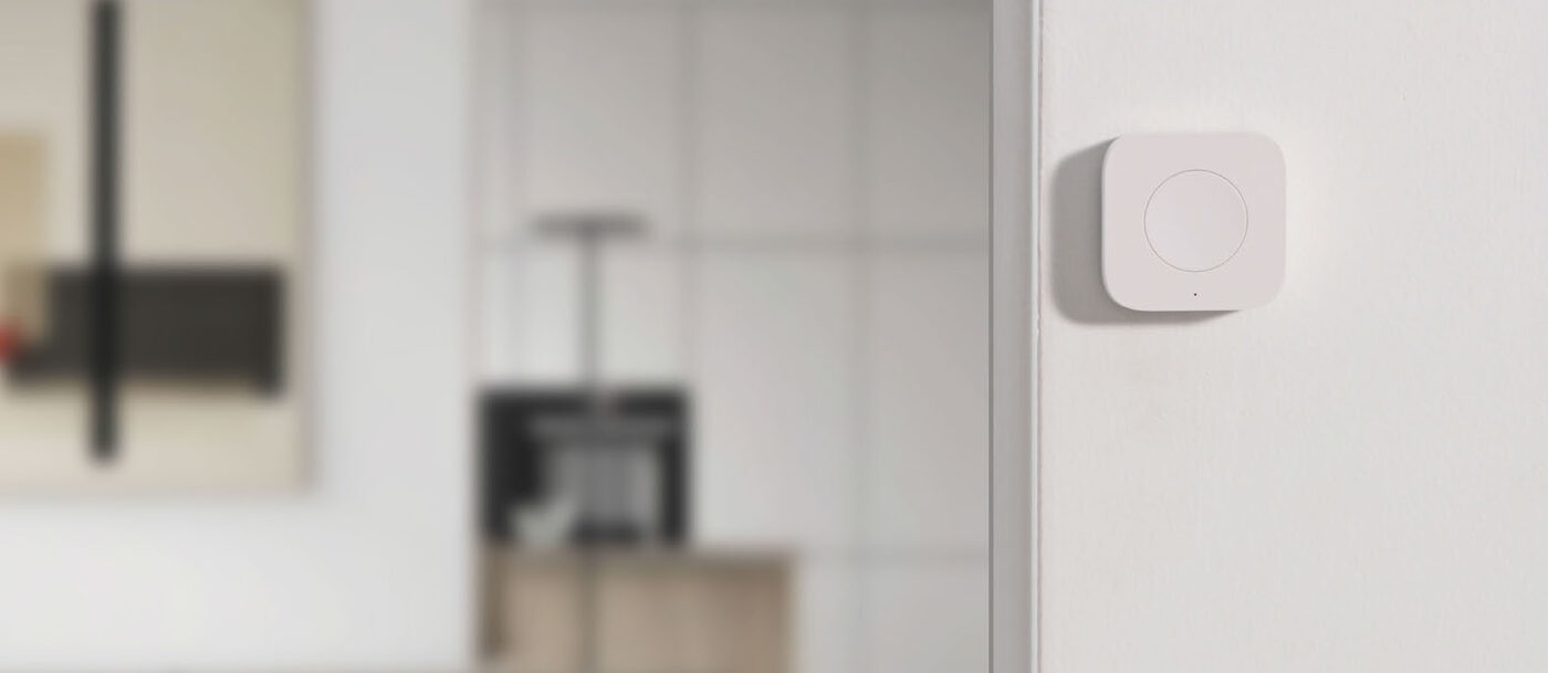 Wireless Mini Switch T1 stuck to the edge of a doorway in a bright living room